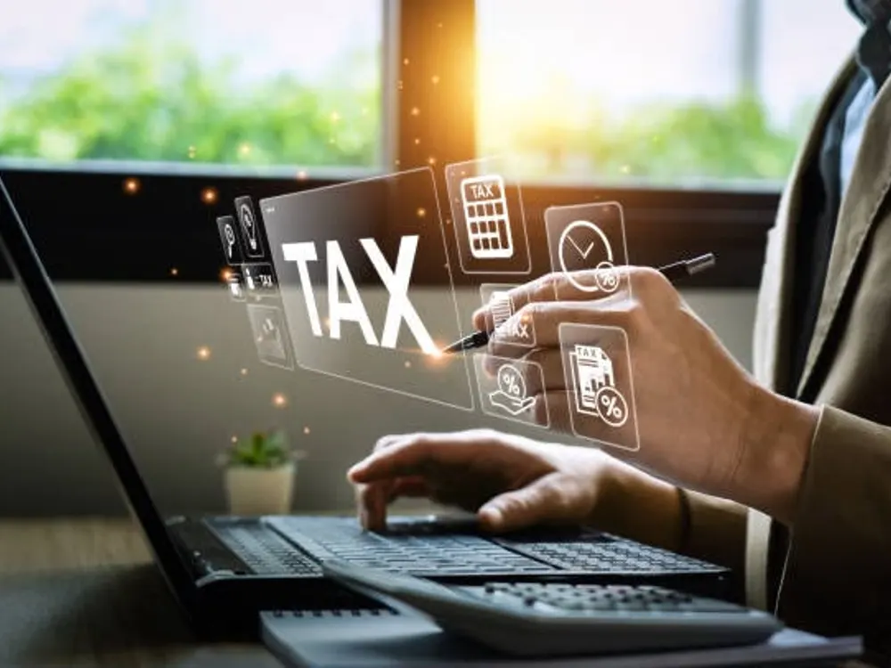 Tax icons floating above a laptop as an accountant works